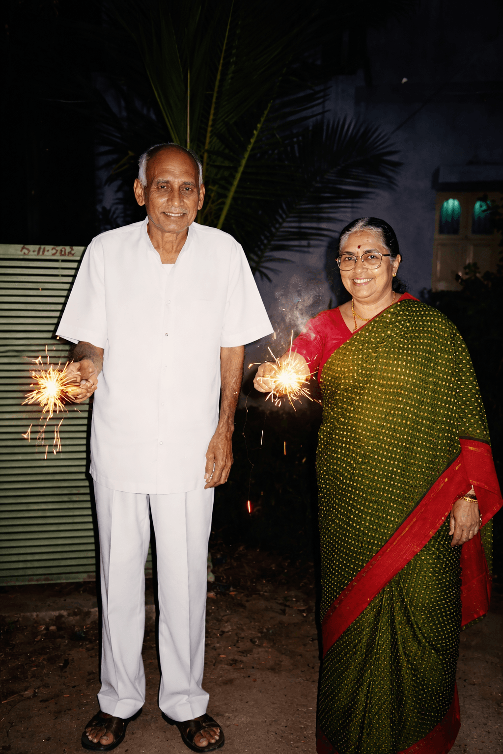 Professor Madiraju Ranga Rao and his wife celebrating a festive occasion with sparklers
